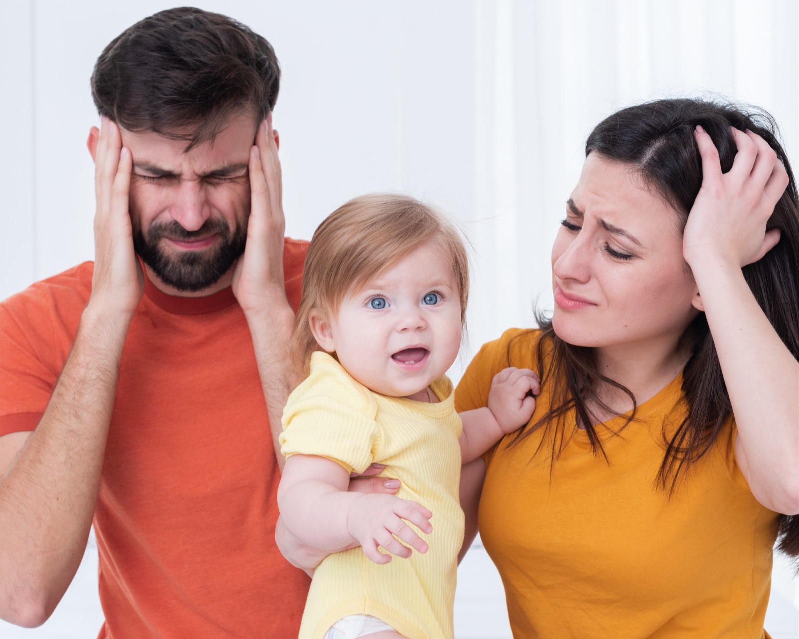 Padres expresando agotamiento junto a su bebé